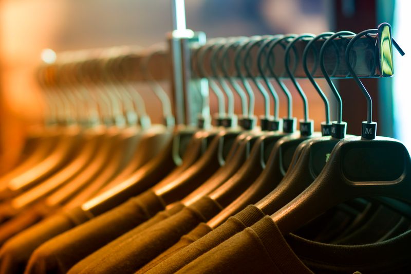 Remeras colgadas en perchas en una tienda de ropa